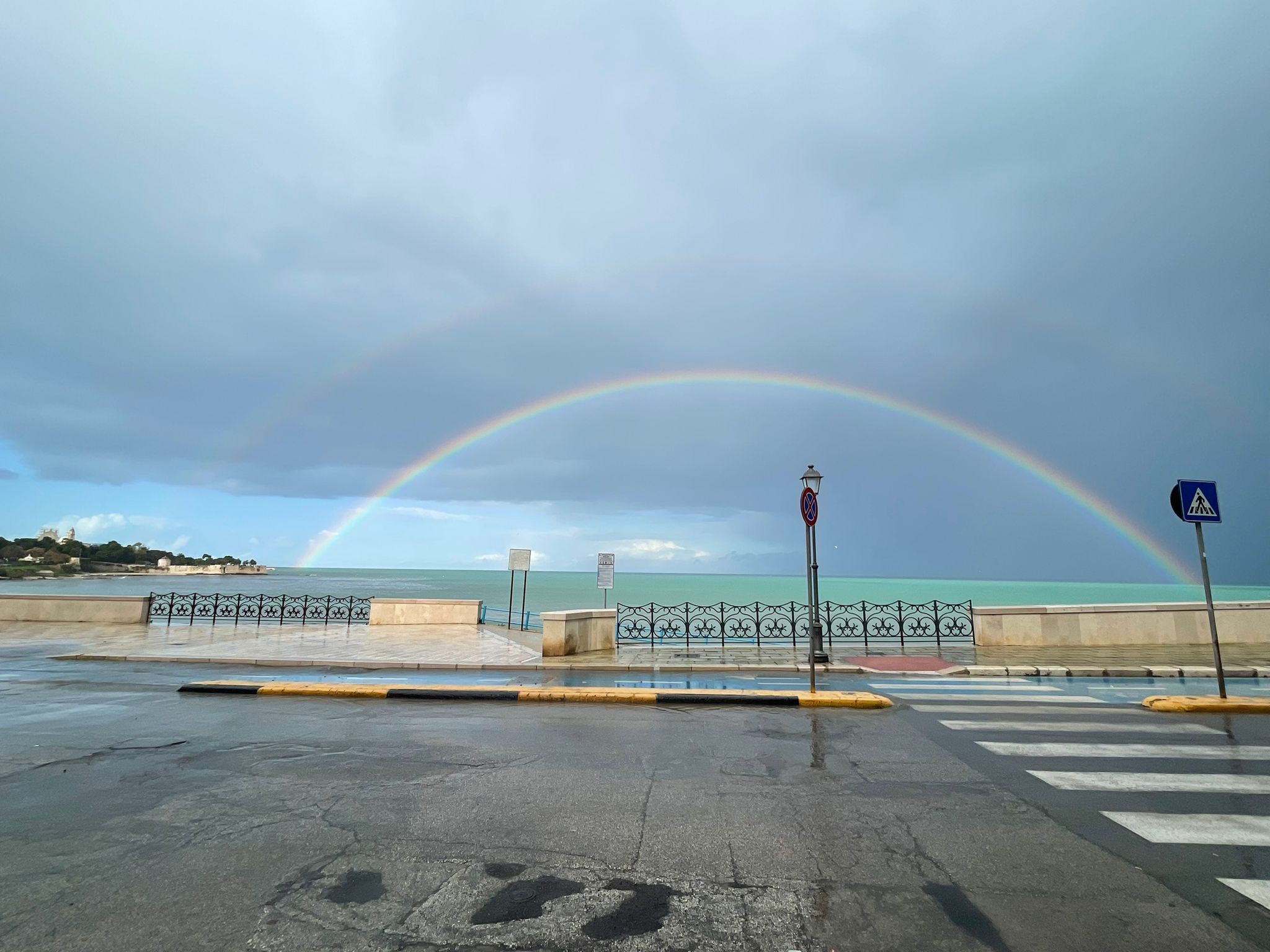 Trani, la magia dopo l’acquazzone: l’arcobaleno abbraccia il cielo sul lungomare